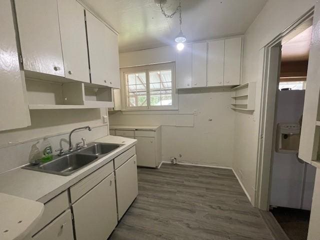 kitchen featuring decorative light fixtures, white cabinets, dark hardwood / wood-style floors, and sink