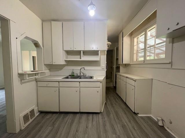 kitchen with dark hardwood / wood-style flooring, sink, and white cabinets