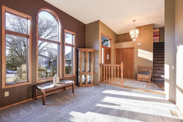 entryway featuring carpet and an inviting chandelier