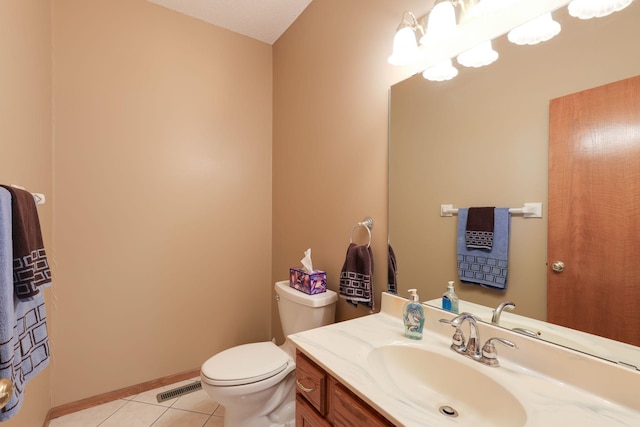 bathroom with toilet, vanity, and tile patterned floors