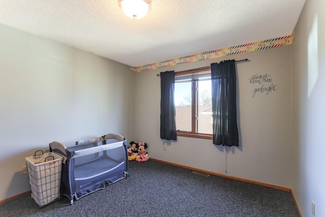 interior space with a textured ceiling and dark carpet