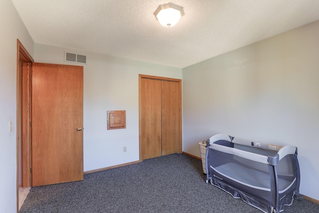 interior space with dark carpet and a textured ceiling