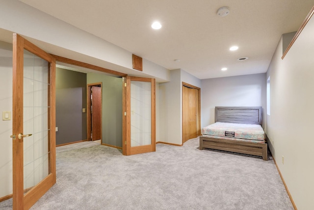 unfurnished bedroom with french doors, light colored carpet, and a closet