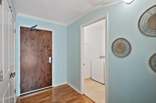 foyer entrance featuring light hardwood / wood-style flooring, ornamental molding, and washer / dryer