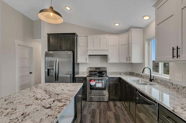 kitchen with lofted ceiling, appliances with stainless steel finishes, white cabinetry, sink, and decorative light fixtures