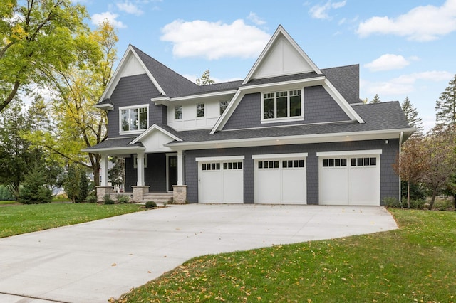 craftsman inspired home with a front yard, a garage, and covered porch