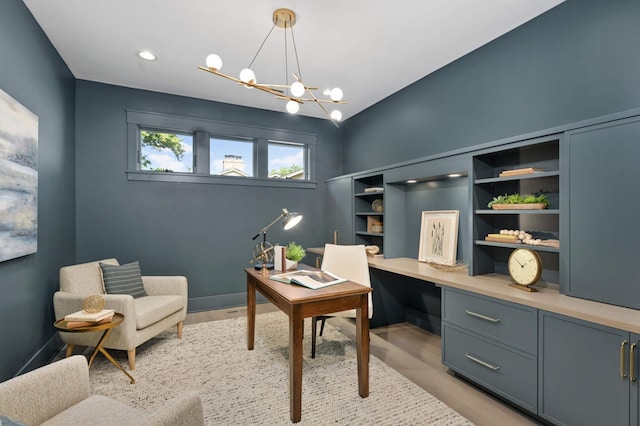 office area featuring built in desk, light hardwood / wood-style floors, and a chandelier