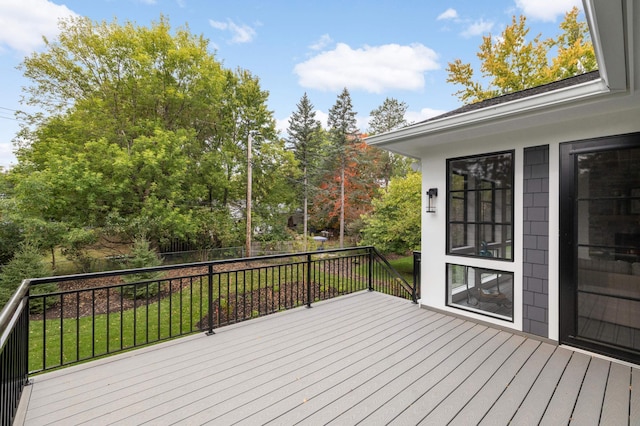 wooden deck featuring a lawn