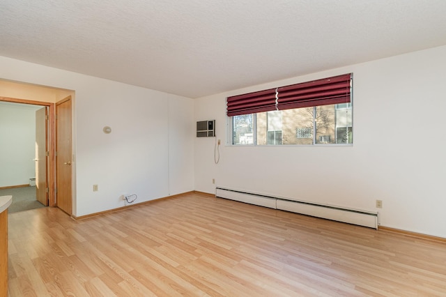 unfurnished room with a baseboard heating unit, light hardwood / wood-style floors, and a textured ceiling