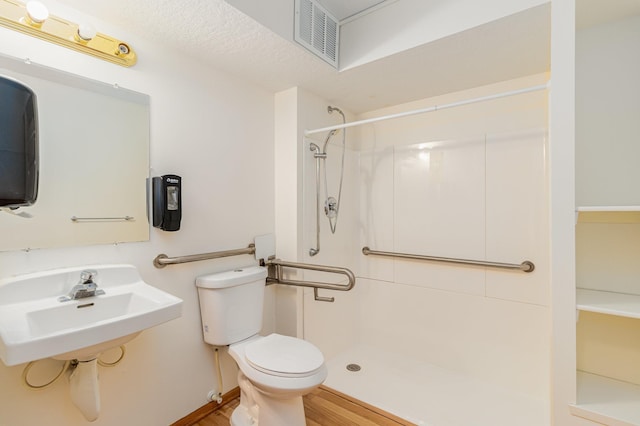 bathroom with toilet, hardwood / wood-style flooring, sink, and walk in shower