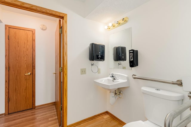 bathroom featuring a textured ceiling, toilet, and hardwood / wood-style flooring