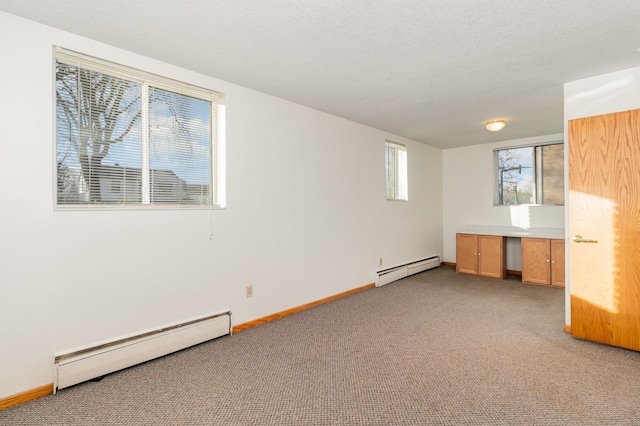 interior space with a textured ceiling, baseboard heating, and carpet floors