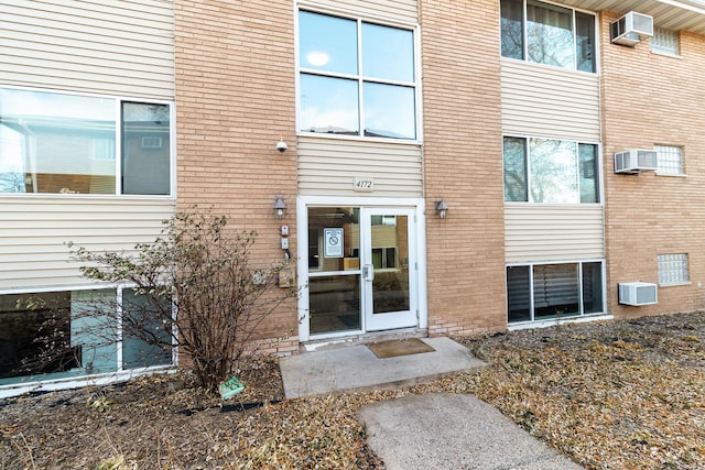 view of exterior entry featuring a wall mounted air conditioner