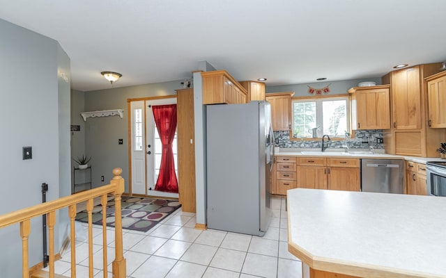 kitchen with backsplash, stainless steel appliances, light tile patterned flooring, sink, and light brown cabinets