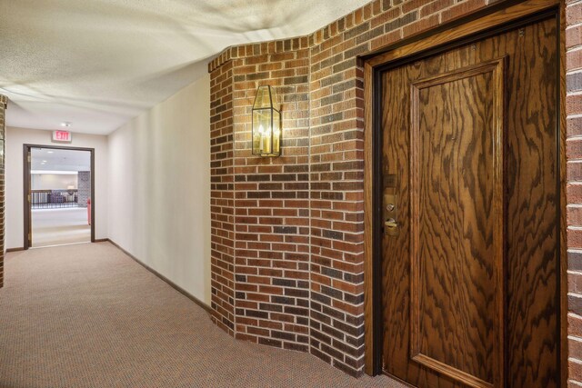 hallway featuring a textured ceiling and carpet