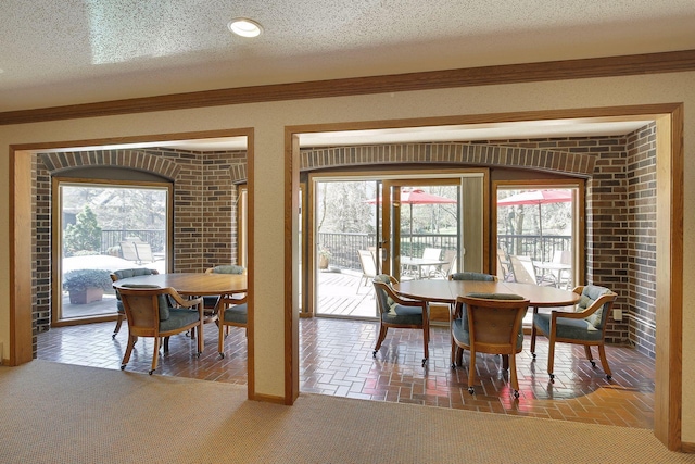 dining area with crown molding, a textured ceiling, and carpet floors