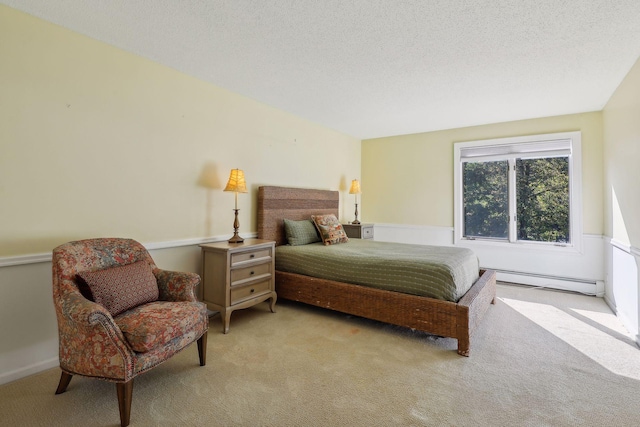 bedroom with a textured ceiling, baseboard heating, and light colored carpet