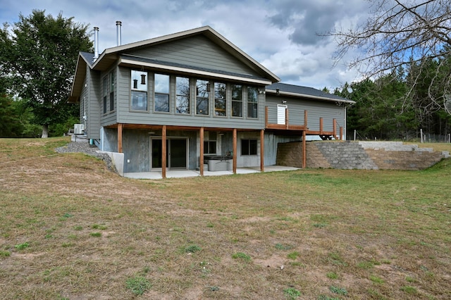 back of property with a yard and a patio area