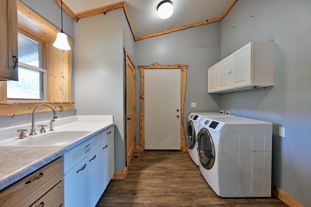 washroom featuring cabinet space, baseboards, washer and clothes dryer, dark wood-style flooring, and a sink