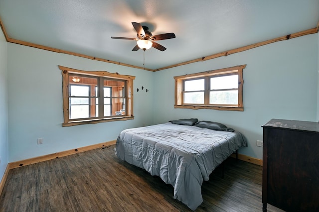 bedroom with a ceiling fan, crown molding, baseboards, and wood finished floors