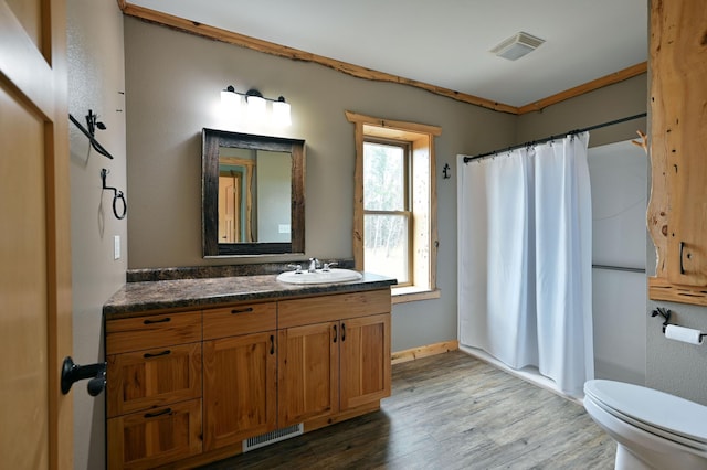 full bathroom with toilet, visible vents, wood finished floors, and vanity