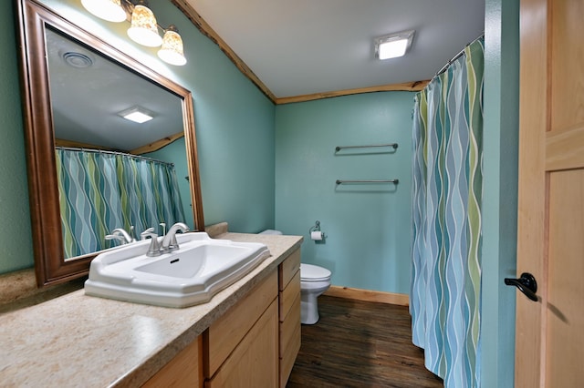 full bath featuring toilet, wood finished floors, vanity, baseboards, and crown molding