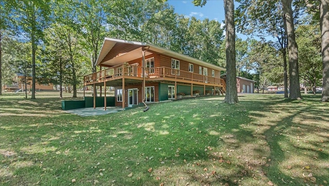 back of property featuring a wooden deck, a yard, and a patio area