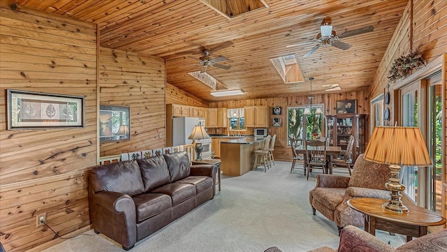 living room with ceiling fan, wooden walls, light carpet, and wooden ceiling