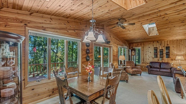 15520 Tamarac Cir NE, Miltona, MN 56354 - carpeted dining room featuring wooden ceiling, wood walls, and vaulted ceiling with skylight
