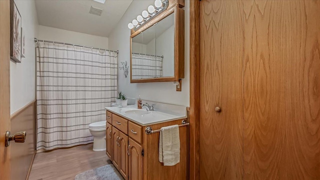 15520 Tamarac Cir NE, Miltona, MN 56354 - bathroom featuring toilet, wood finished floors, curtained shower, visible vents, and vanity