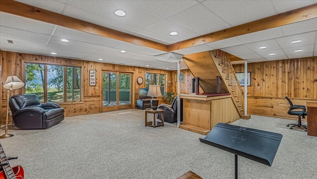 interior space featuring wooden walls, carpet floors, and a paneled ceiling