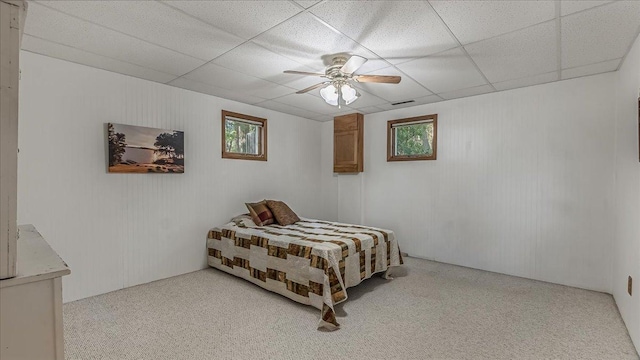 carpeted bedroom with a drop ceiling and ceiling fan