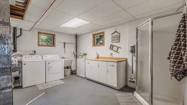 laundry area with sink, washer and dryer, and cabinets