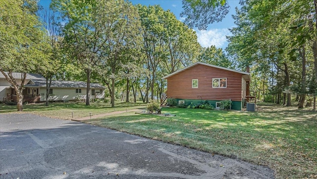 view of side of home with a lawn and central air condition unit