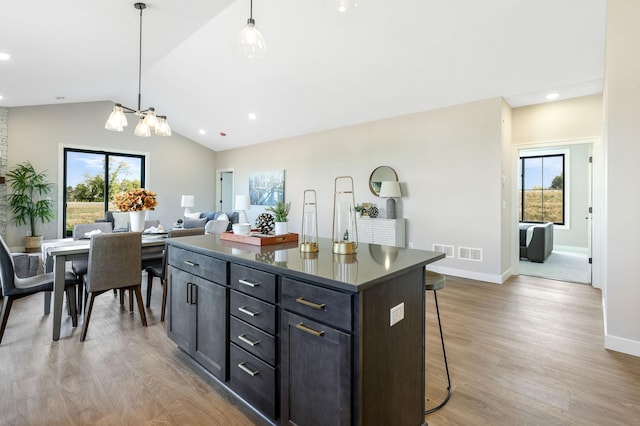 kitchen featuring lofted ceiling, hanging light fixtures, a wealth of natural light, and a kitchen island