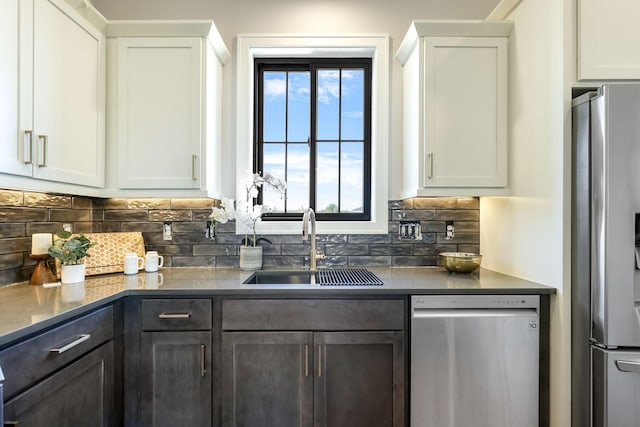 kitchen with white cabinetry, stainless steel appliances, sink, and tasteful backsplash