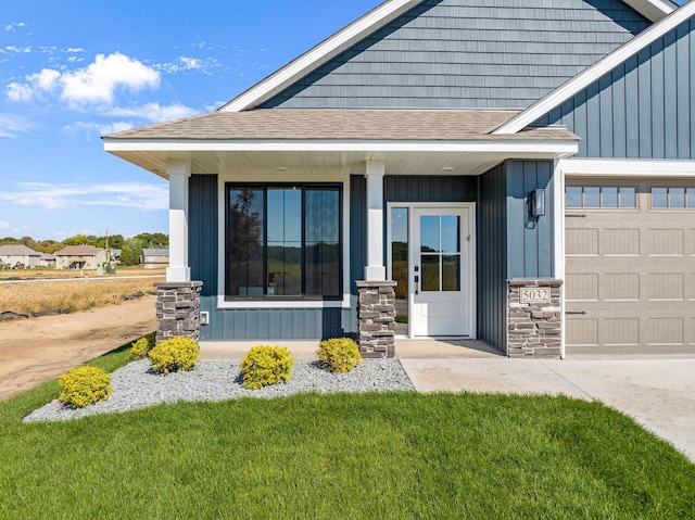 entrance to property with a garage, a porch, and a yard