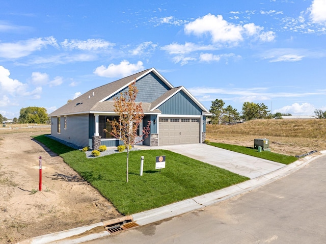 view of front facade with covered porch, a front yard, and a garage