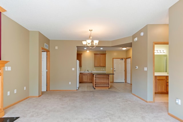 kitchen featuring hanging light fixtures, a chandelier, light colored carpet, and white fridge