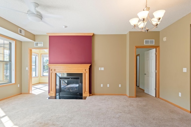 unfurnished living room with carpet floors, ceiling fan with notable chandelier, and a textured ceiling