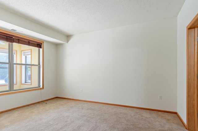 carpeted empty room with a textured ceiling