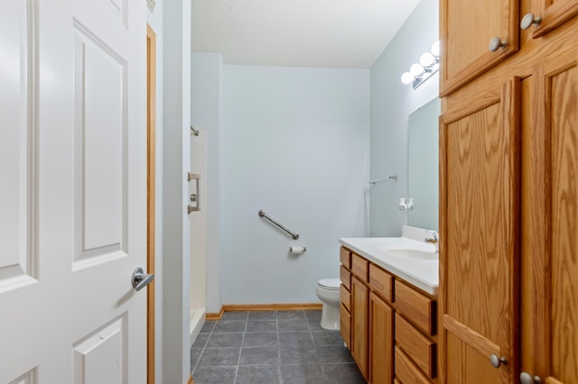 bathroom with vanity, tile patterned flooring, and toilet