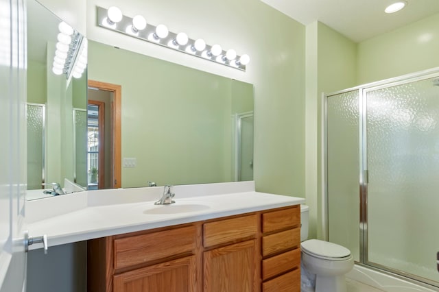 bathroom featuring walk in shower, vanity, and toilet