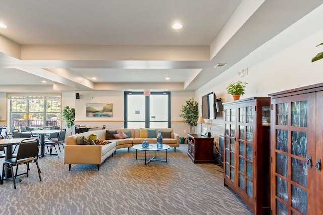 living room with a raised ceiling and carpet floors