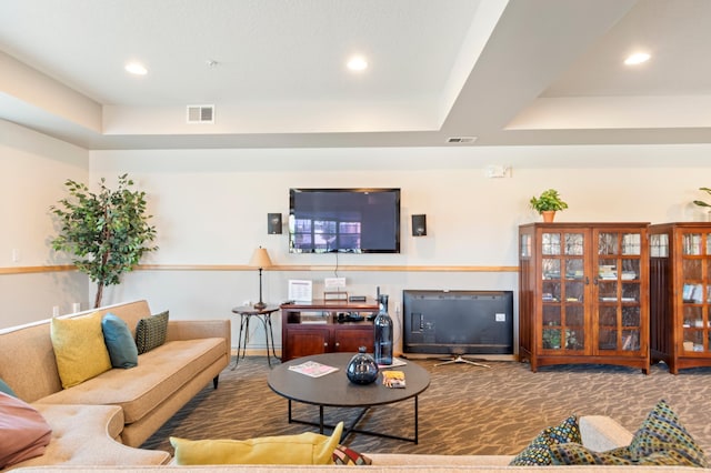 living room featuring a raised ceiling and carpet floors