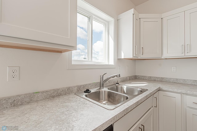 kitchen featuring white cabinetry and sink