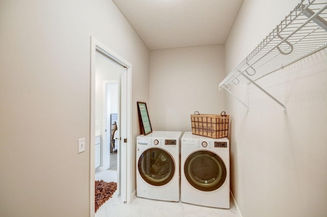 laundry area with a textured ceiling and washing machine and clothes dryer