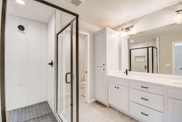 bathroom featuring a textured ceiling, vanity, toilet, and an enclosed shower