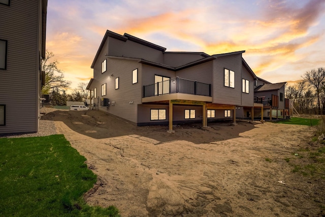 back house at dusk featuring central AC unit, a yard, and a wooden deck