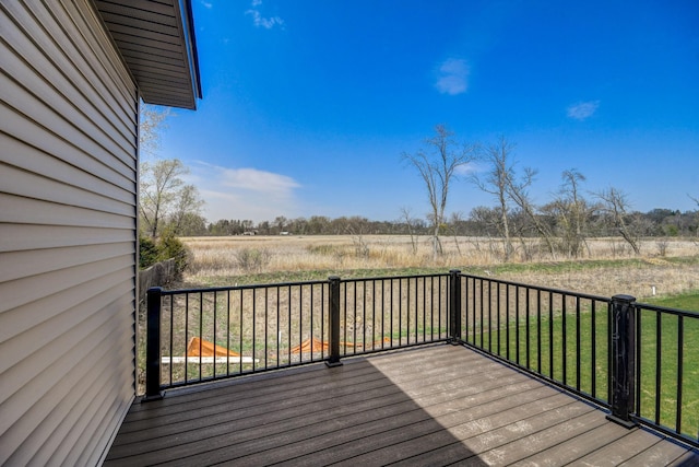 deck with a yard and a rural view